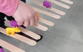 Dzieci ustawiające na drewnianych patyczkach po lodach figurki zwierząt